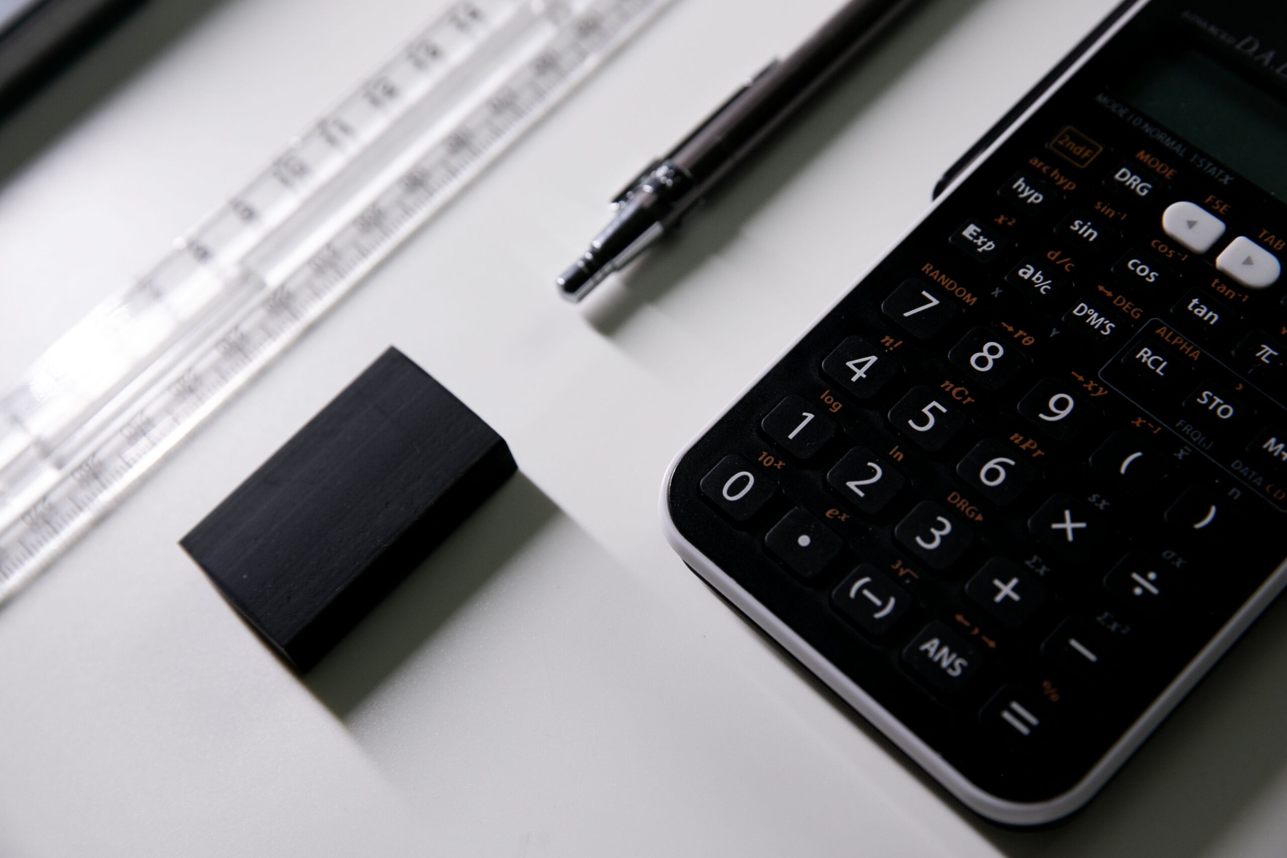A calculator, pen, ruler, and eraser arranged for working through remainder patterns in modular arithmetic.
