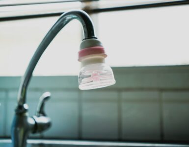 A small water filter attached to a kitchen faucet above the sink