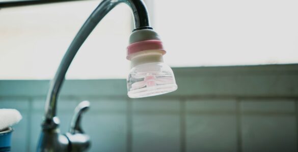 A small water filter attached to a kitchen faucet above the sink