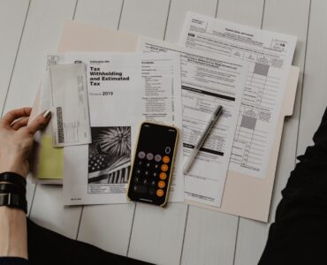 Calculator and financial paperwork used to estimate student loan repayment costs