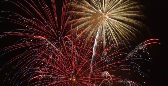 Red, gold, and white fireworks bursting against a dark night sky