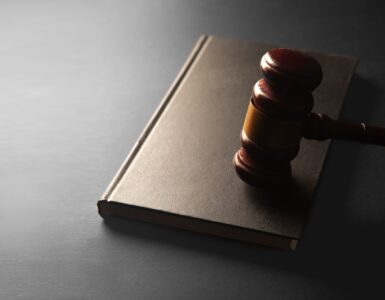 A wooden gavel resting on a closed law book for a civics discussion
