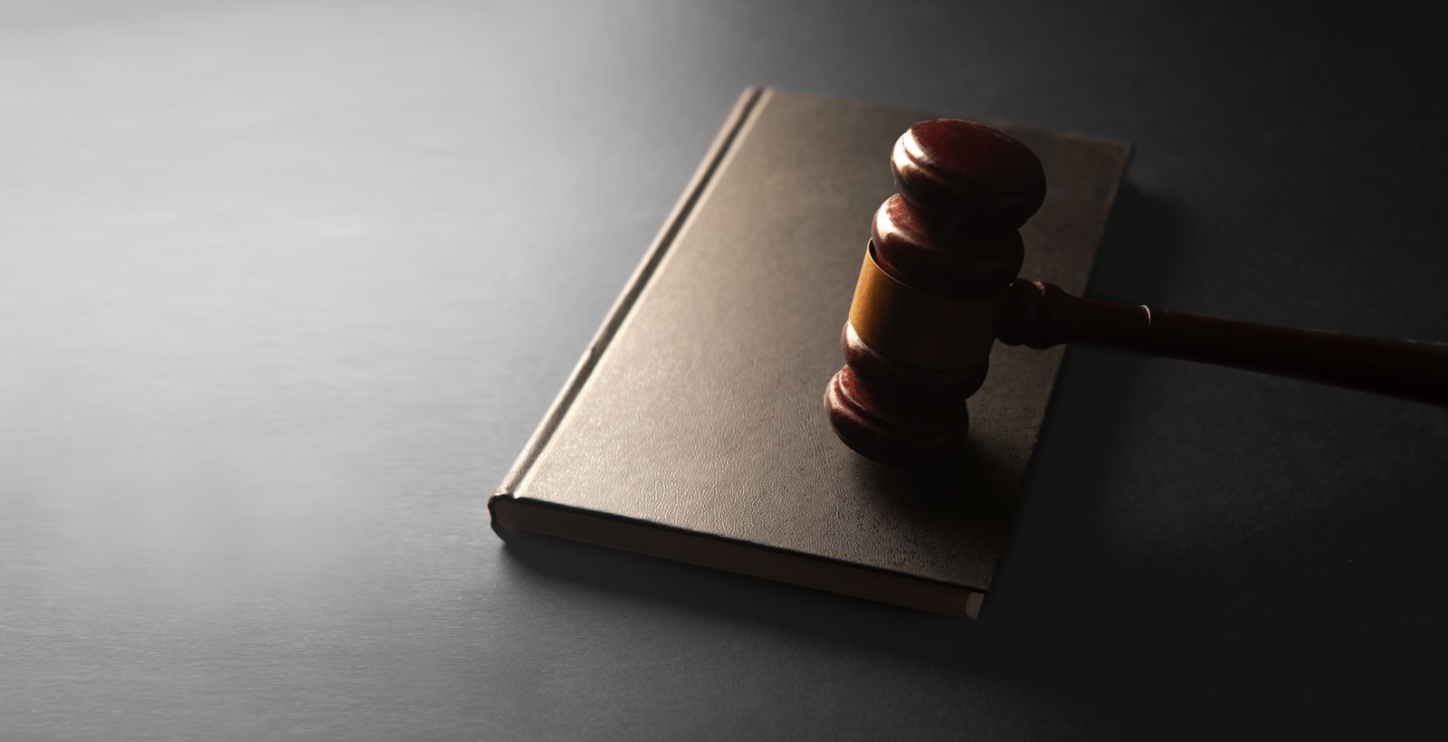 A wooden gavel resting on a closed law book for a civics discussion