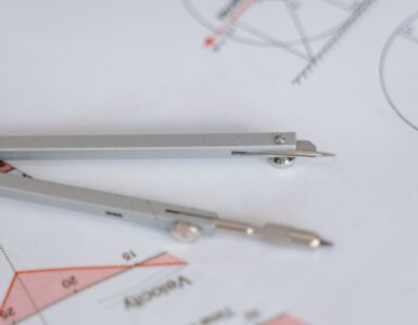 A compass and ruler resting on a geometry diagram