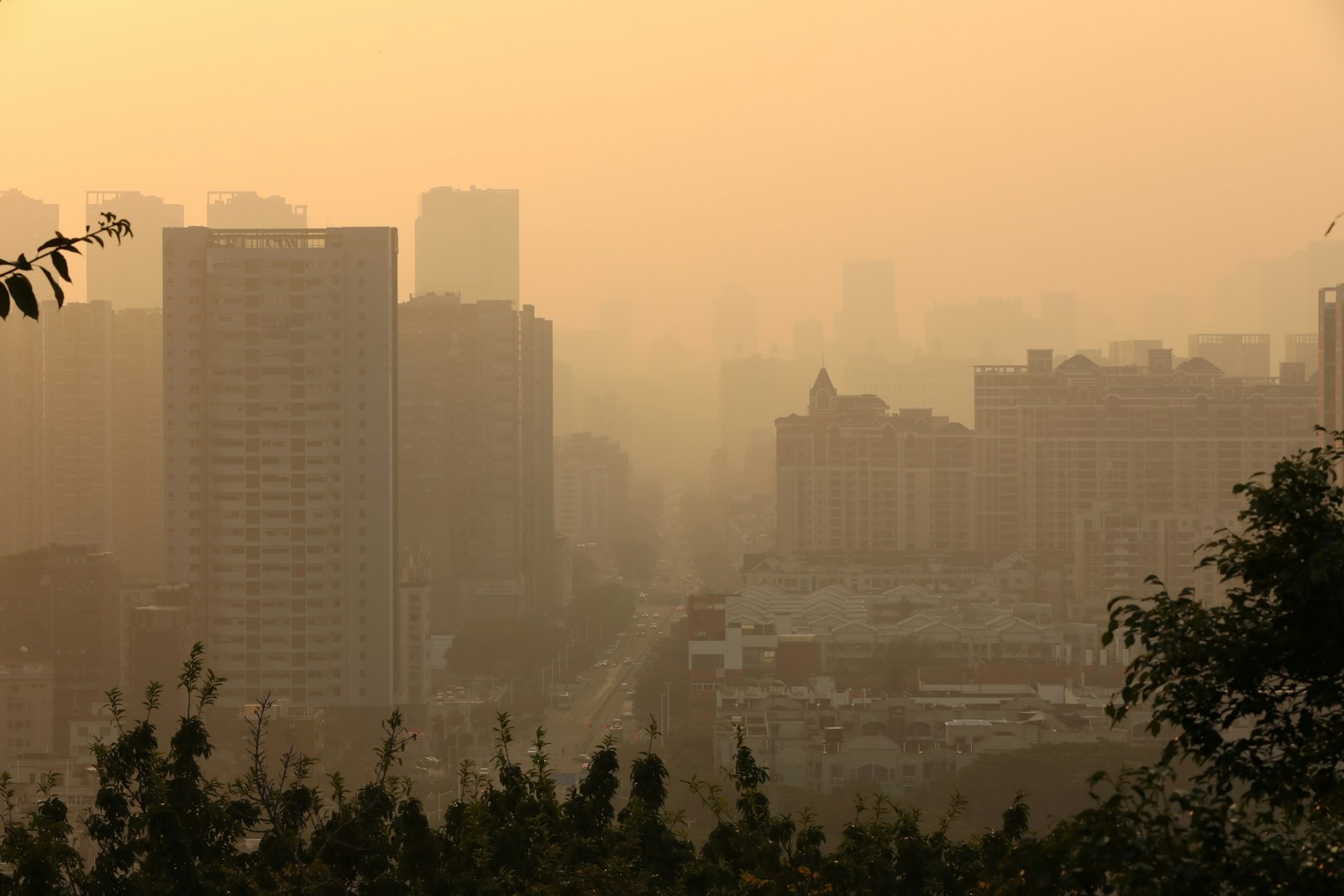 A city skyline partly hidden by orange haze and air pollution