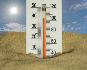 A thermometer in bright summer heat showing high temperatures