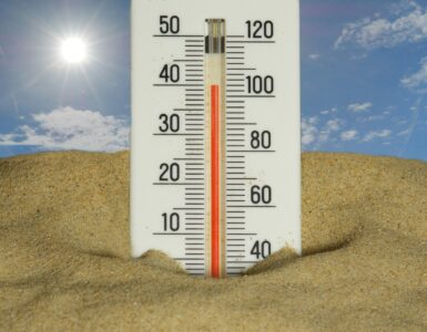 A thermometer in bright summer heat showing high temperatures