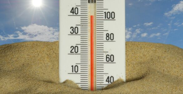 A thermometer in bright summer heat showing high temperatures
