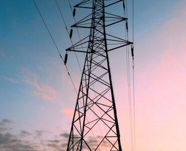 High-voltage transmission tower against a warm sunset sky