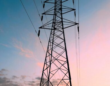 High-voltage transmission tower against a warm sunset sky