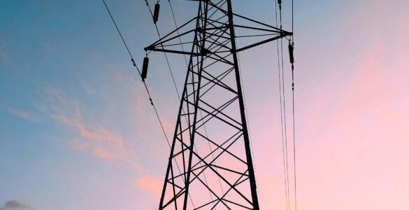 High-voltage transmission tower against a warm sunset sky