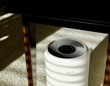 A portable home air purifier sitting under a table in a room