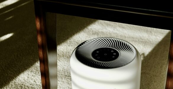 A portable home air purifier sitting under a table in a room