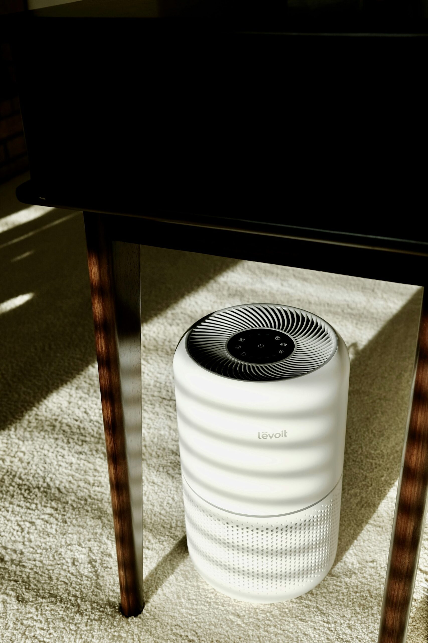 A home air purifier sitting under a table