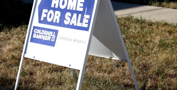 A home for sale sign on a lawn representing a house purchase before appraisal