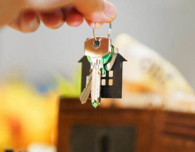 House keys, money, and a wallet representing insurance costs and household risk decisions