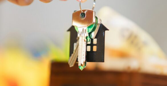 House keys, money, and a wallet representing insurance costs and household risk decisions