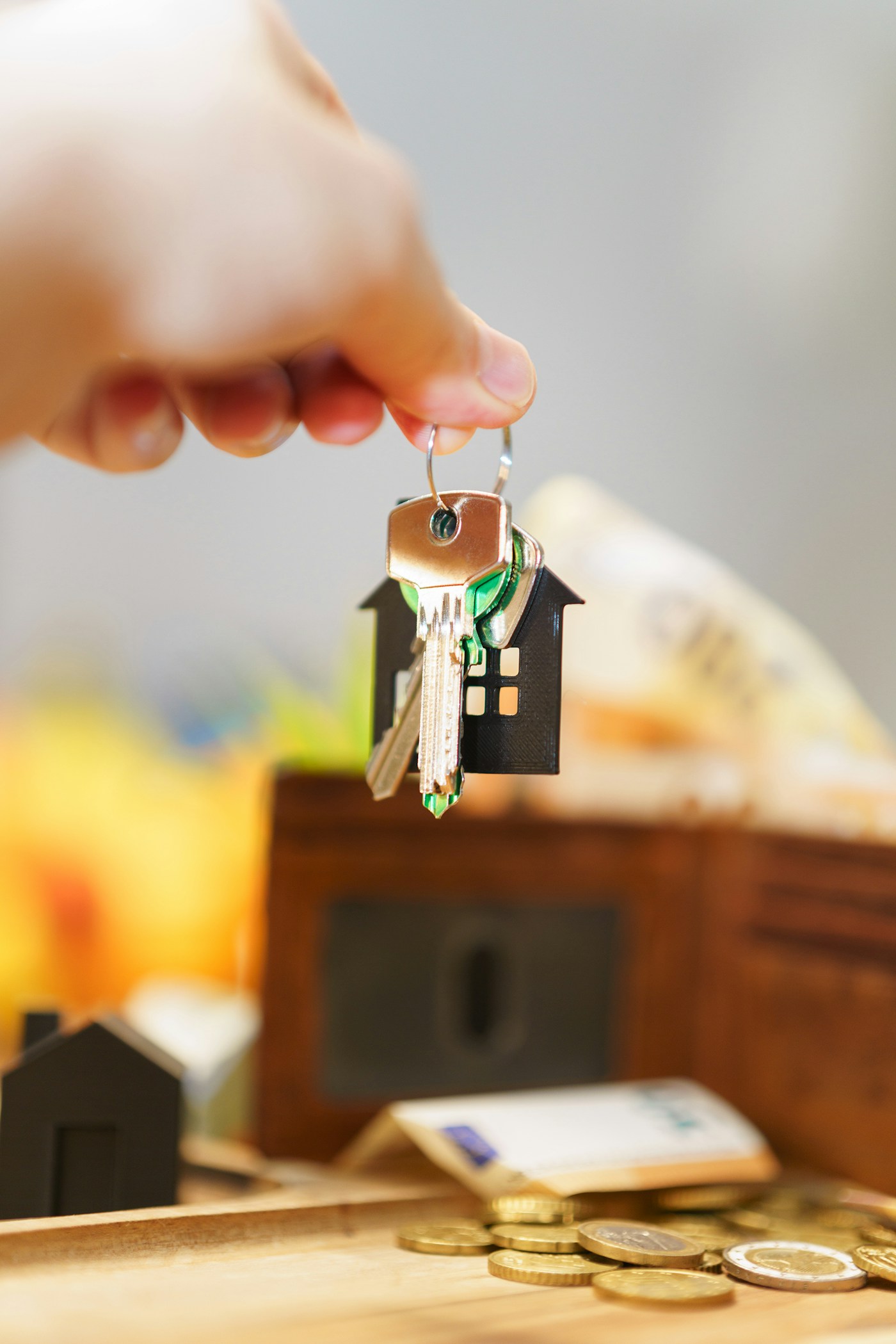 House keys, money, and a wallet representing homeownership costs