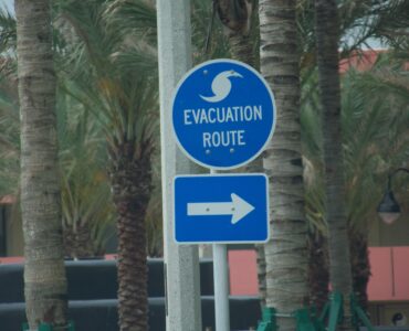 A blue hurricane evacuation route sign near a road in Florida.