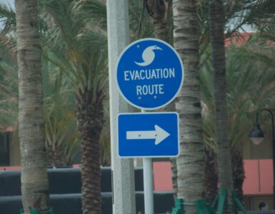 A blue hurricane evacuation route sign near a road in Florida.