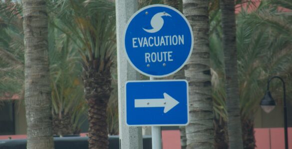 A blue hurricane evacuation route sign near a road in Florida.
