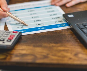 A calculator beside paperwork showing interest rate figures for a real interest rate explanation.