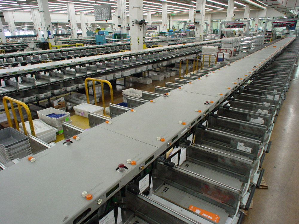 A mail sorting assembly line with trays and conveyors for routing letters