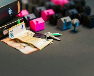 House keys, documents, and money arranged on a table for a mortgage payment explanation