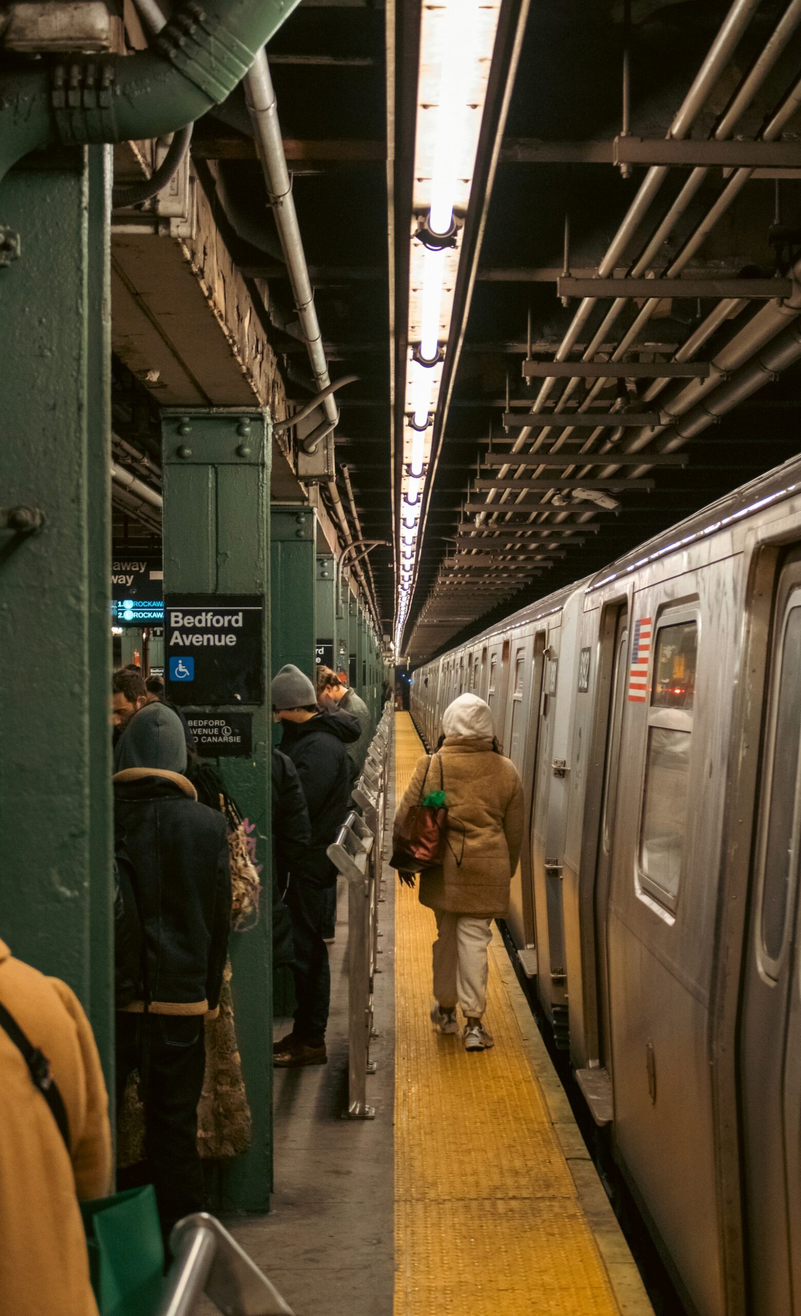 Commuters waiting on a New York subway platform beside a train
