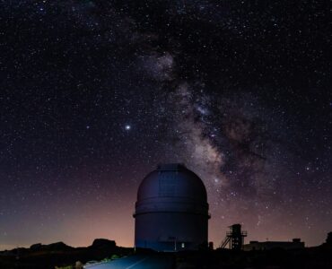 An observatory dome beneath the Milky Way in a dark night sky.