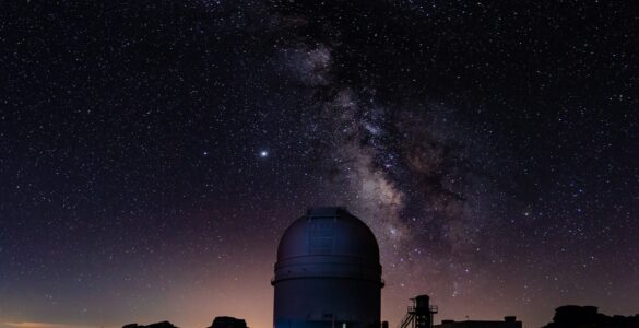 An observatory dome beneath the Milky Way in a dark night sky.