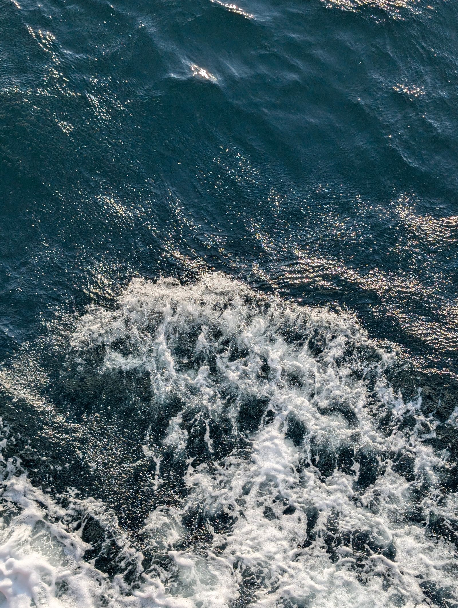 Foamy ocean waves seen from above showing motion across the water