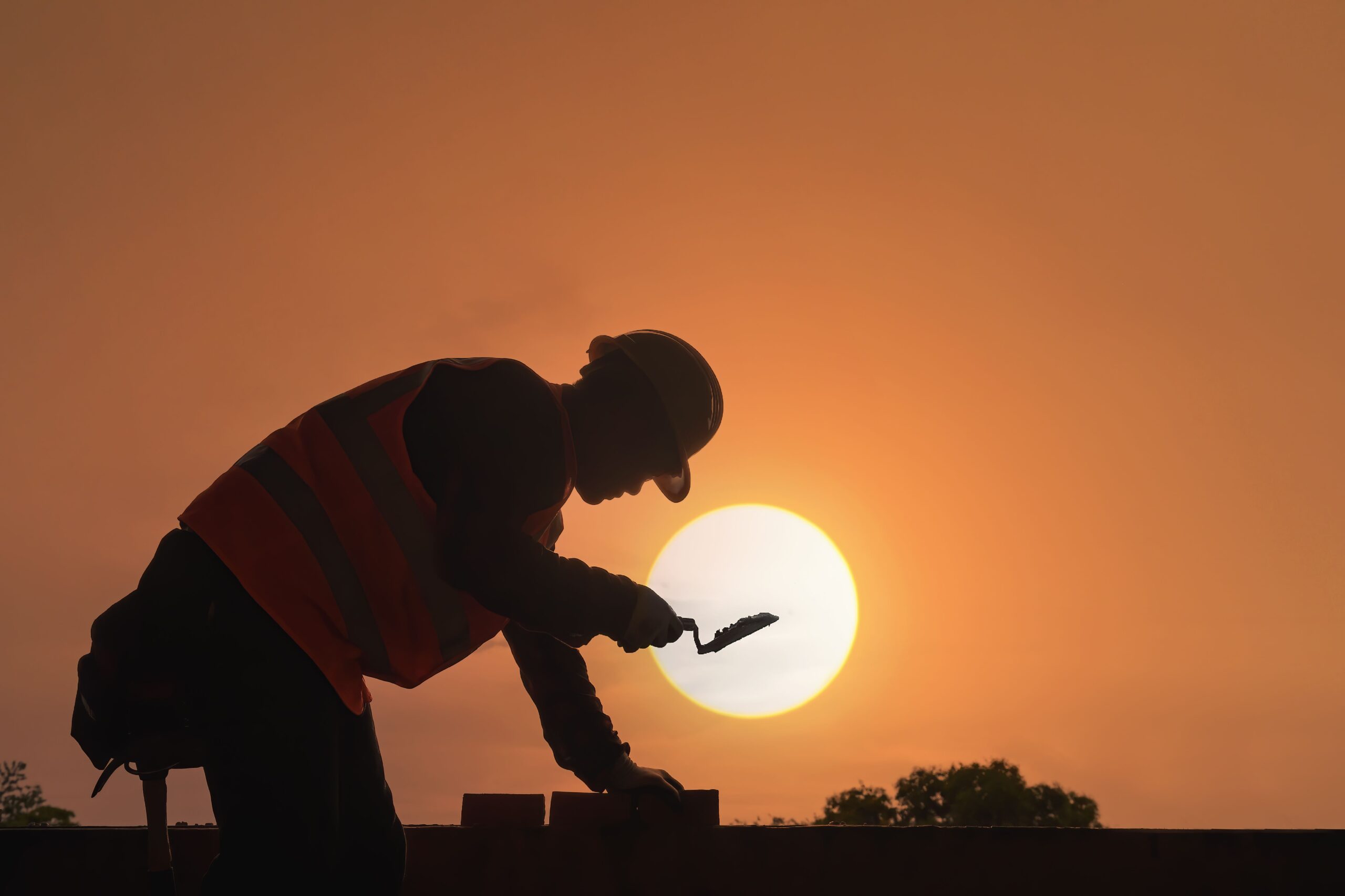 A construction worker in strong sun, showing why heat risk matters for outdoor work.