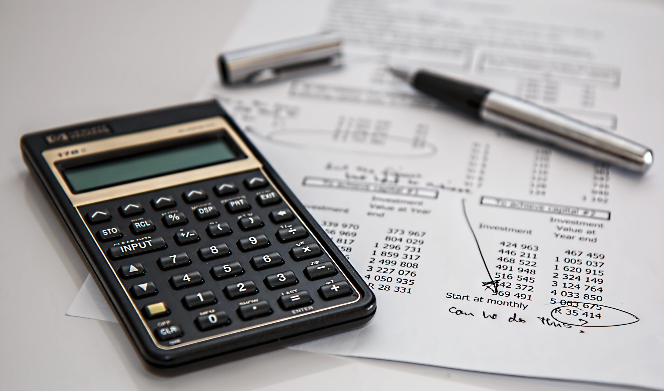 A calculator and paperwork on a desk for budgeting take-home pay.