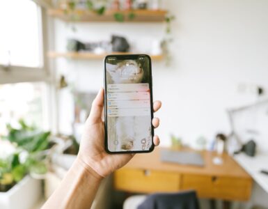 A hand holding a smartphone with notifications visible on the lock screen