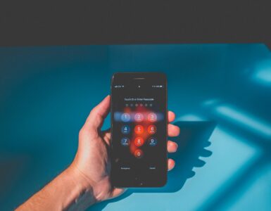 A hand holding a smartphone with a passcode screen for account security