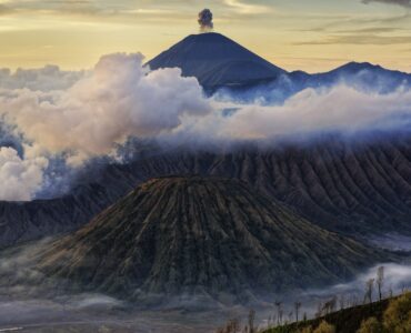 Volcanic mountains rising above clouds in Indonesia.
