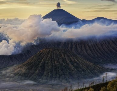 Volcanic mountains rising above clouds in Indonesia.