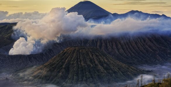 Volcanic mountains rising above clouds in Indonesia.