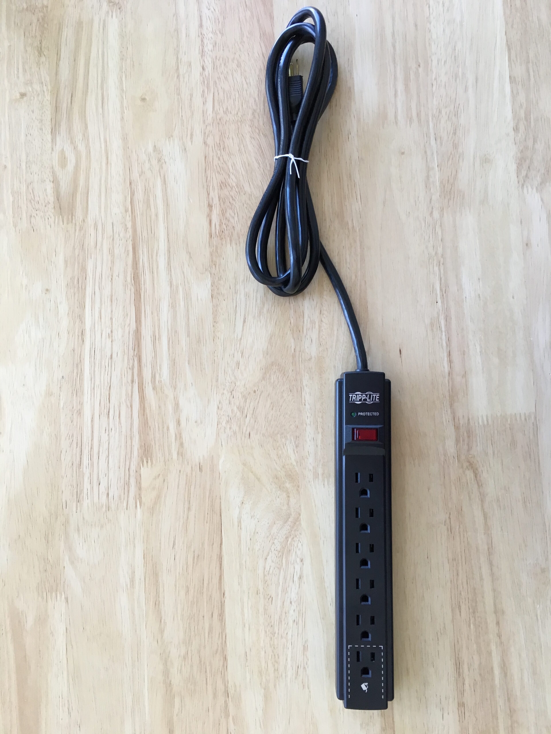 A power strip and extension cord arranged on a white surface