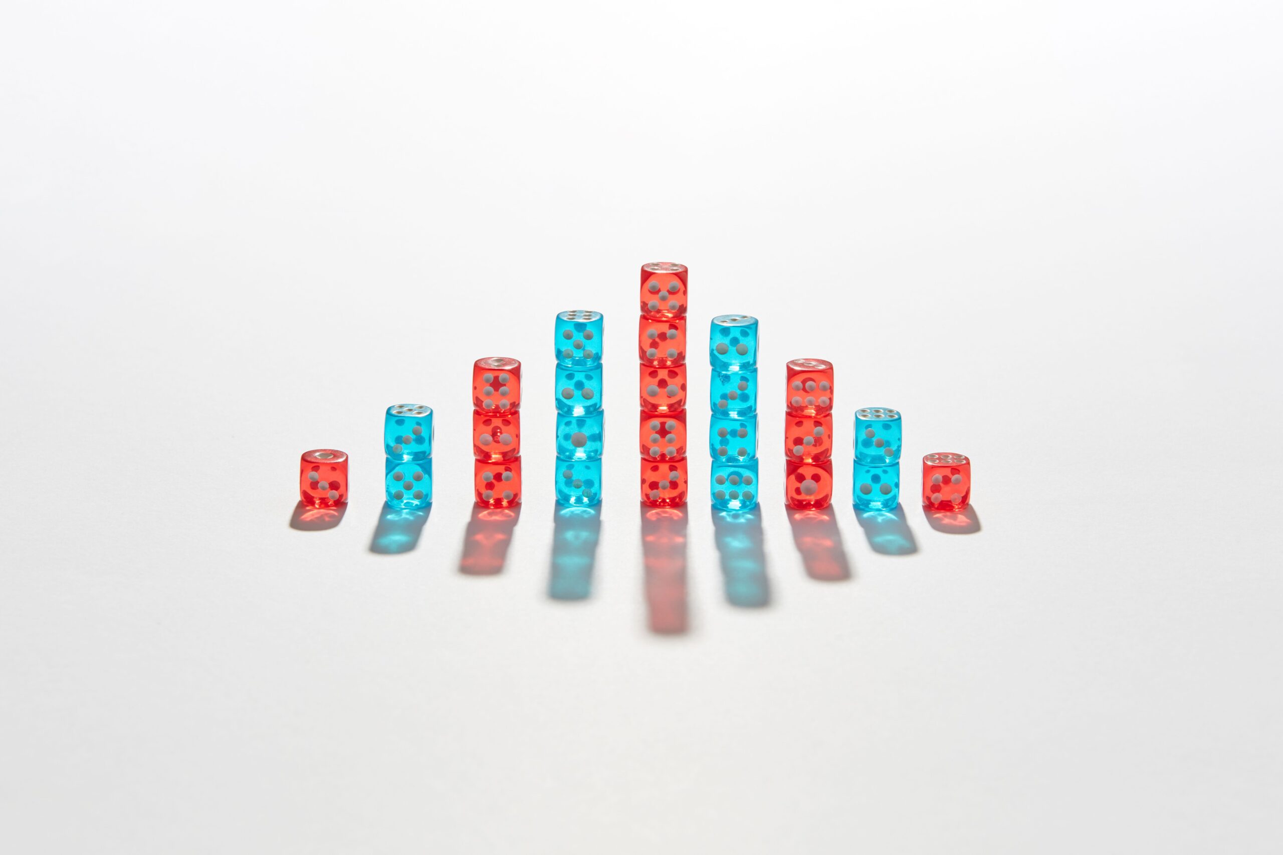 Red and blue dice stacked in different heights to suggest a probability distribution.