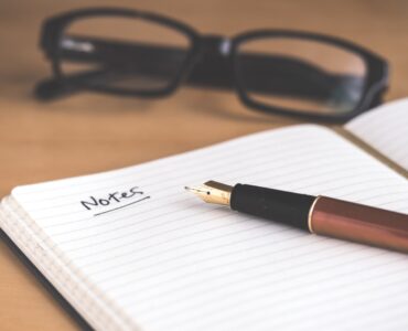 A notebook and pen used to prepare notes for a college recommendation letter request.