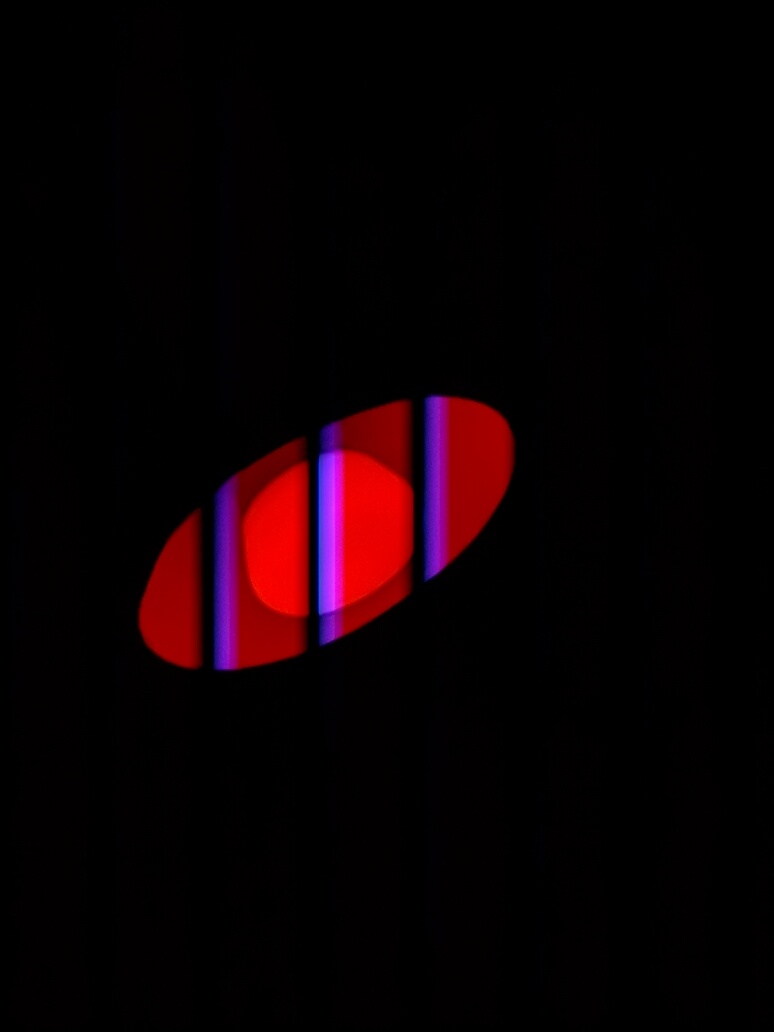 A colored LED light photographed with bands caused by pulse-width modulation and rolling shutter.