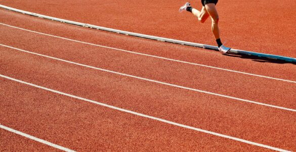 A runner on a sunny outdoor track, where heat and humidity can change safe exercise conditions.
