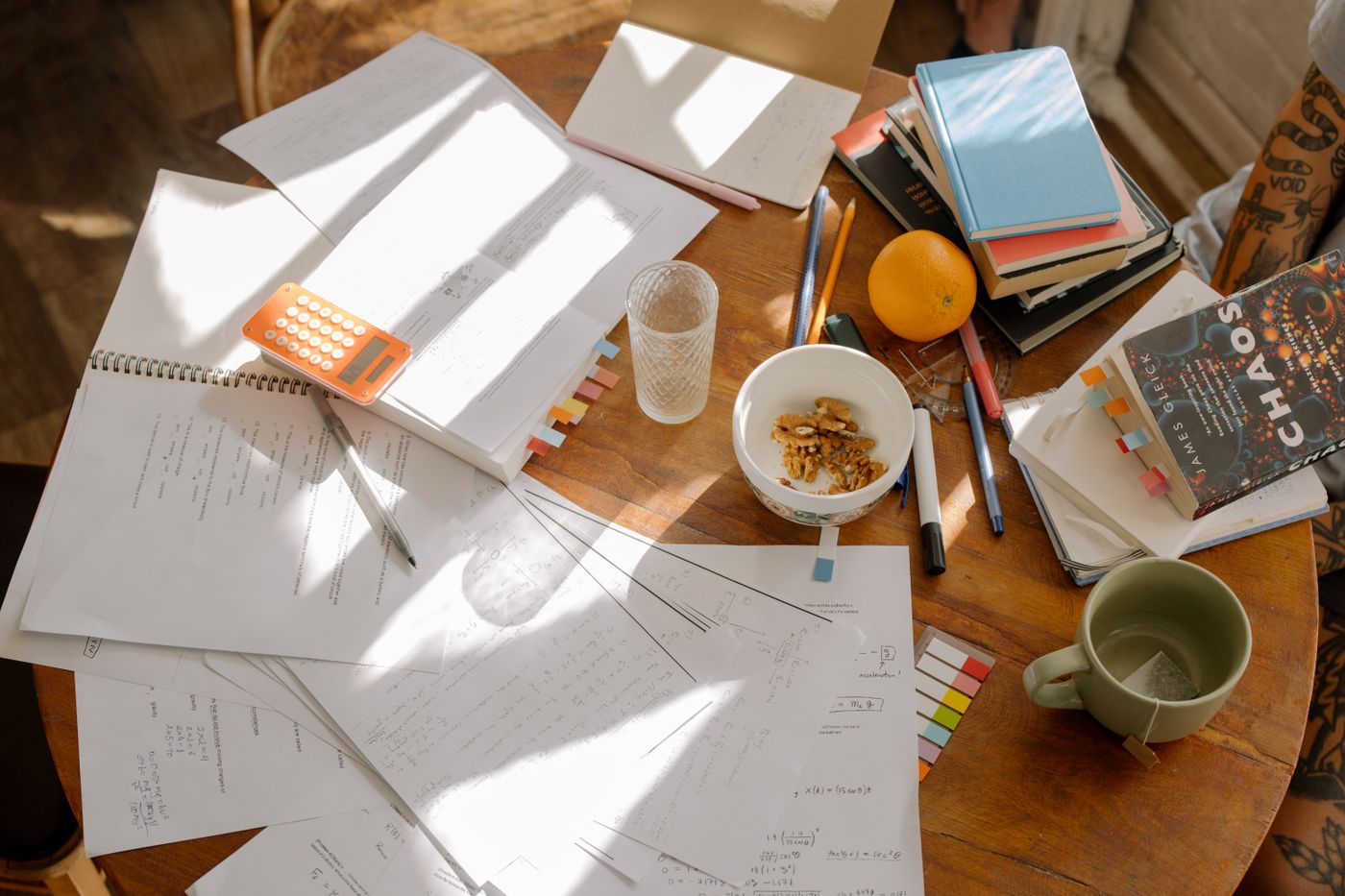 A student reviewing study notes on a laptop beside a notebook