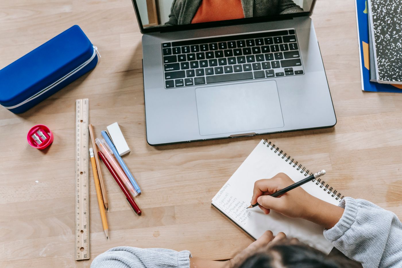 A student organizing papers and notes beside a laptop