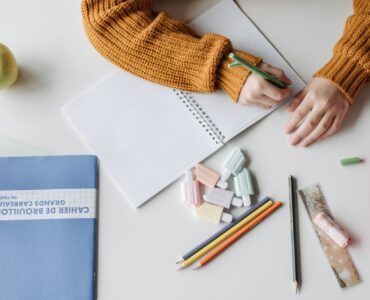 A student revises sentence fragments and complete sentences in a notebook