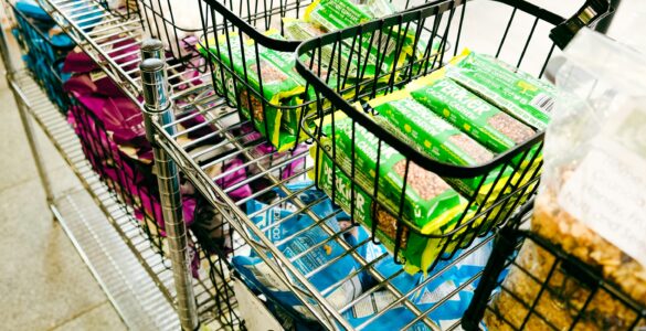 A shopping cart filled with groceries, representing how one low advertised price can lead to a larger purchase.