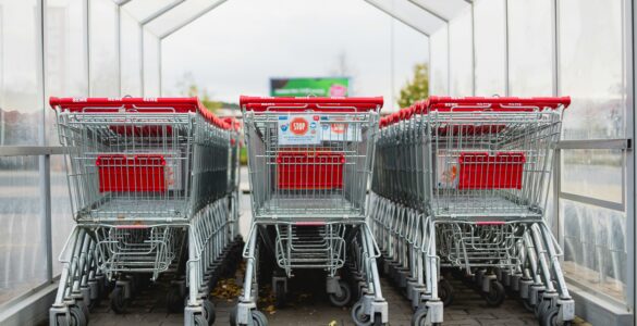 Rows of shopping carts at a store entrance, representing retail pricing and shopper promotions.