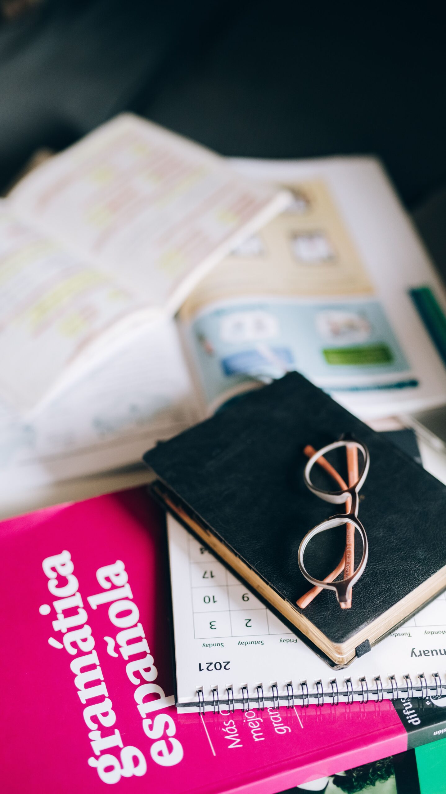 Spanish grammar book and study materials on a desk